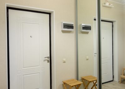 Hallway interior, large fitted wardrobe with large mirrors on the doors, entrance metal door